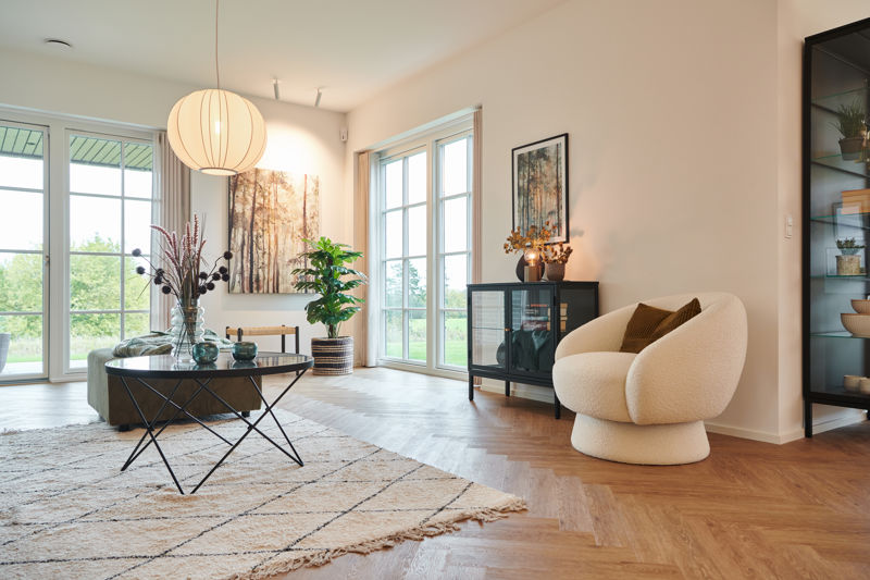 Lyst køkken-alrum fra eurodan-huse med store vinduespartier mod haven, spisebord, køkkenø, lyse gardiner og bred åbning ud mod terrasse – inspiration til nybyggeri, husbyggeri og husdrømme med fokus på dagslys og åbne rum.