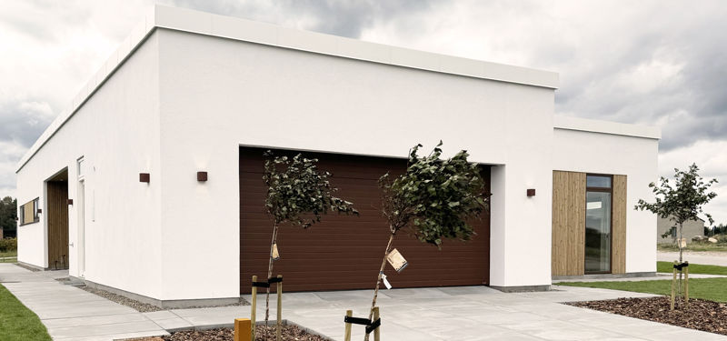 Moderne hvidt funkishus med fladt tag, integreret dobbeltgarage og flisebelagt indkørsel – inspiration til nybyggeri og et stilrent nyt eurodan-hus.