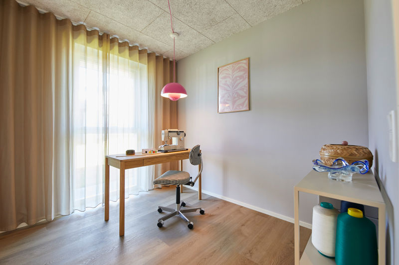 Kreativt hobbyrum i nybyggeri med sybord, symaskine, stort vinduesparti og moderne indretning – inspiration til fleksible rum i det nye hus.