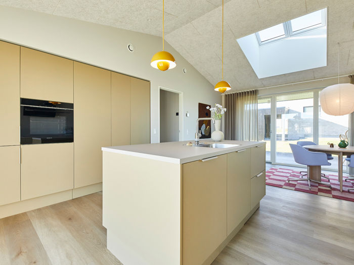 Indbydende køkken-alrum fra eurodan-huse med køkkenø, spiseplads, moderne armatur, trælook gulv og gode arbejdszoner – inspiration til husdrømme og nybyggeri.