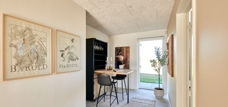 Indbydende gangareal i nybyggeri med lille vinbar, udgang til haven og dekorative detaljer – inspiration til personlige husdrømme