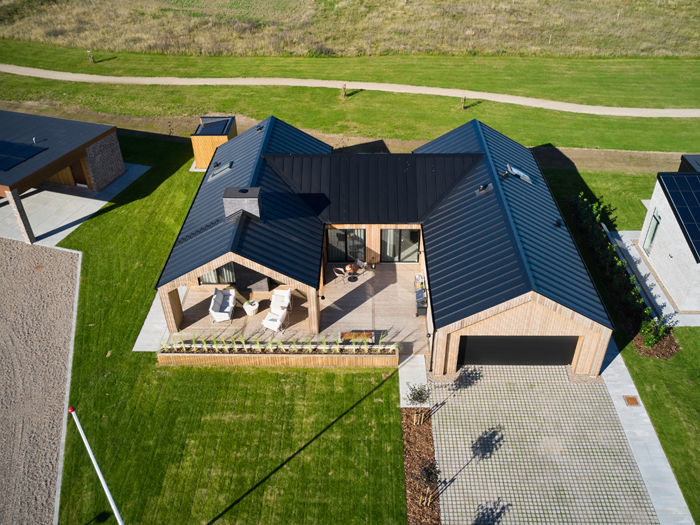 Barnhouse fra eurodan-huse med sort tag, træbeklædning, integreret garage og terrasse som samler hus og have