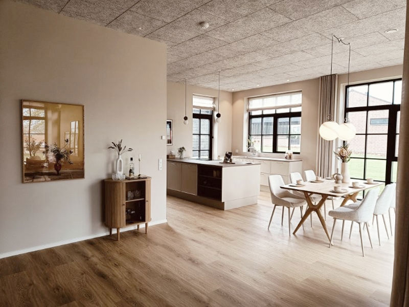 Åbent køkken-alrum fra eurodan-huse med køkkenø, spiseplads, lyse fronter, trælook gulv, naturligt dagslys og sammenhæng mellem køkken og opholdsrum – konkret inspiration til nybyggeri, husbyggeri og indretning af et nybygget hus.