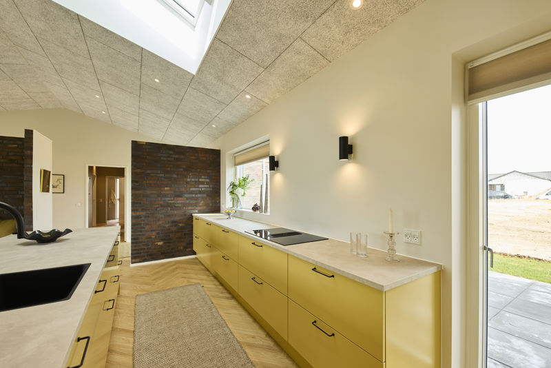 Moderne køkken fra eurodan-huse med køkkenø, lyse fronter, integrerede skabe, diskret bordplade og spiseplads tæt på madlavningen – inspiration til køkken-alrum i nybygget hus.