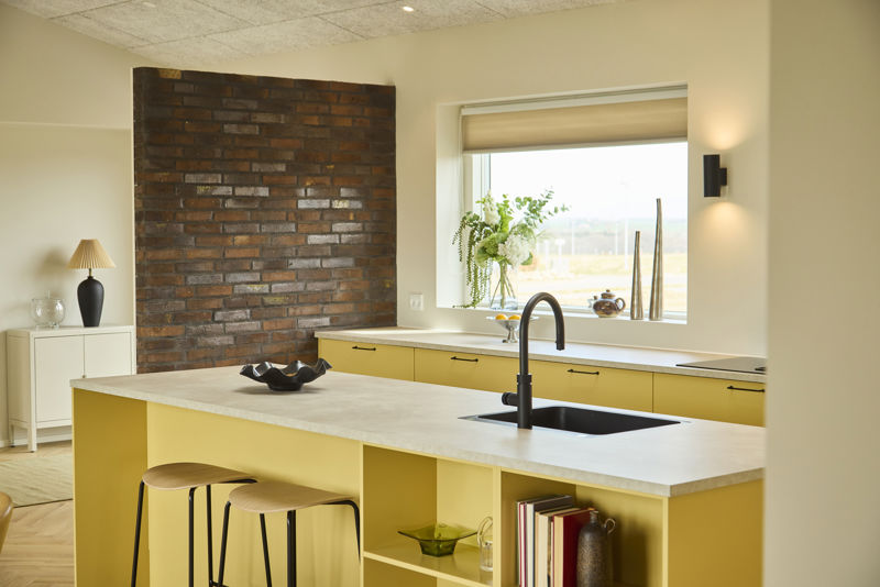 Detalje af køkkenø fra eurodan-huse med bordplade, armatur, skuffer og praktisk arbejdszone tæt på spisepladsen – inspiration til køkkenindretning i nybyggeri.