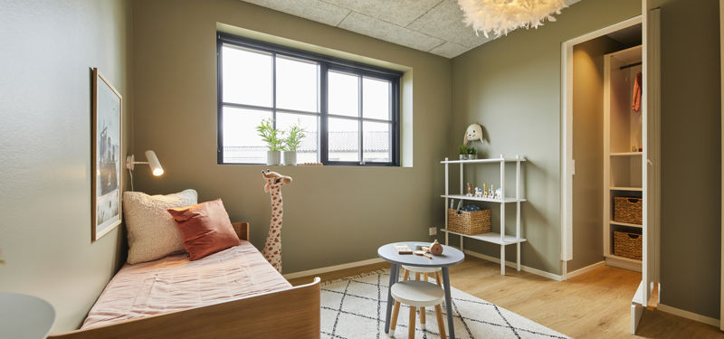 Børneværelse fra eurodan-huse med enkeltseng, lille rundt bord, børnestole, hvid reol, stort sort sprossevindue og åben walk-in-opbevaring med hylder – inspiration til praktiske børneværelser, nybyggeri og gennemtænkt husbyggeri.