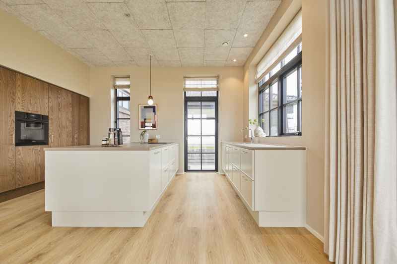 Køkken fra eurodan-huse med lange skabsvægge, køkkenø, integrerede hvidevarer, bordplade og rene minimalistiske linjer – inspiration til nybyggeri og husbyggeri.