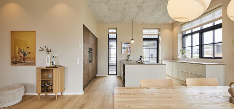 Rummeligt køkken-alrum fra eurodan-huse med åben planløsning, køkkenzone, spiseplads, store vinduespartier og roligt materialevalg – inspiration til nybygget hus.