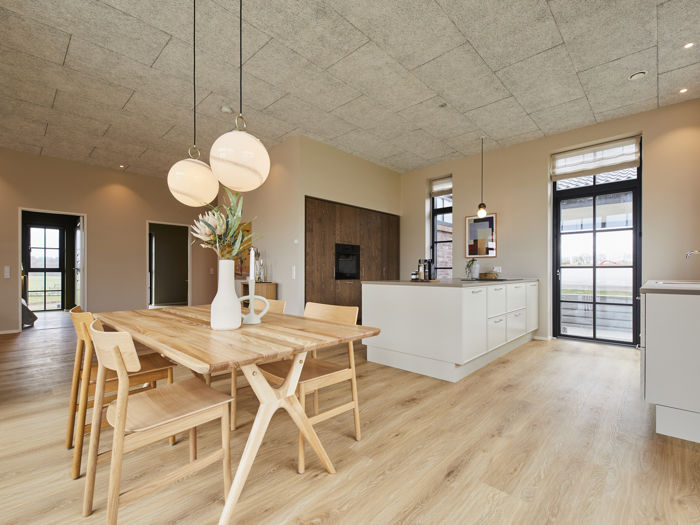 Indbydende køkken-alrum fra eurodan-huse med køkkenø, spiseplads, moderne armatur, trælook gulv og gode arbejdszoner – inspiration til husdrømme og nybyggeri.