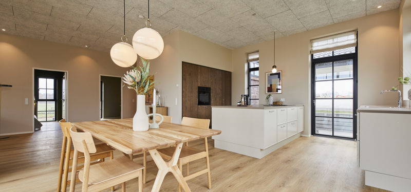 Indbydende køkken-alrum fra eurodan-huse med køkkenø, spiseplads, moderne armatur, trælook gulv og gode arbejdszoner – inspiration til husdrømme og nybyggeri.