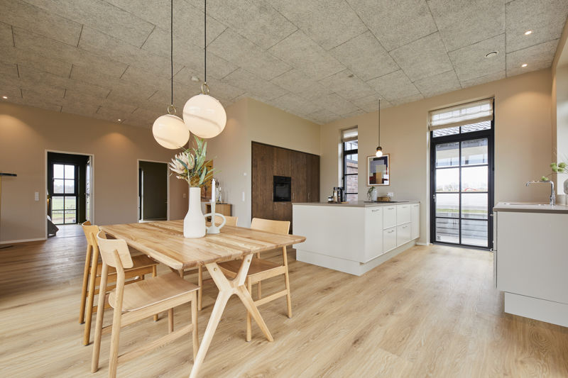 Indbydende køkken-alrum fra eurodan-huse med køkkenø, spiseplads, moderne armatur, trælook gulv og gode arbejdszoner – inspiration til husdrømme og nybyggeri.
