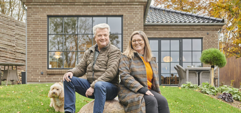 Maiken og Johnny med hunden Sergio foran deres nybyggede drømmehus i Hornbæk.