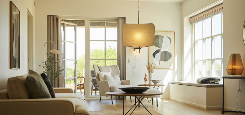 Lys og indbydende stue i moderne udstillingshus med store vinduespartier, elegant indretning og inspiration til nybyggeri