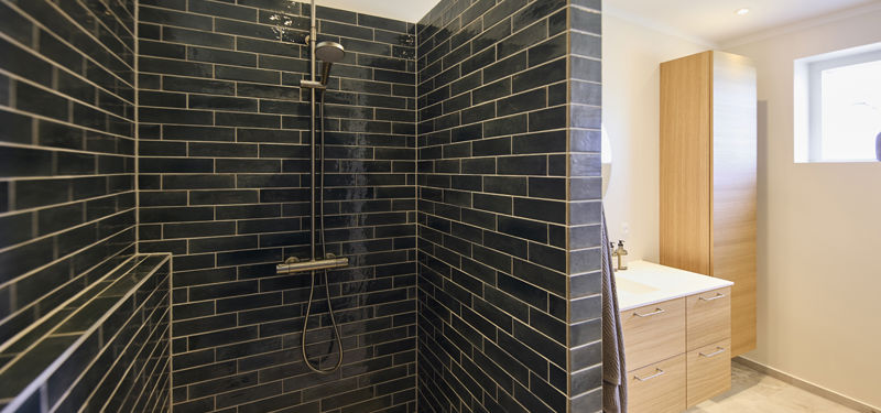 Moderne bruseniche i nybygget udstillingshus med lave klinker og stilrent badeværelsesdesign