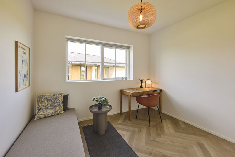 Lyst værelse i udstillingshus fra eurodan-huse med skrivebord, daybed, stort vindue og sildebensgulv, der giver inspiration til kontor, gæsteværelse og fleksible rum i moderne nybyggeri og husbyggeri.