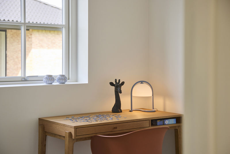 Lyst kontor i udstillingshus fra eurodan-huse med skrivebord, lampe og vindue, der giver inspiration til hjemmearbejdsplads i moderne nybyggeri.