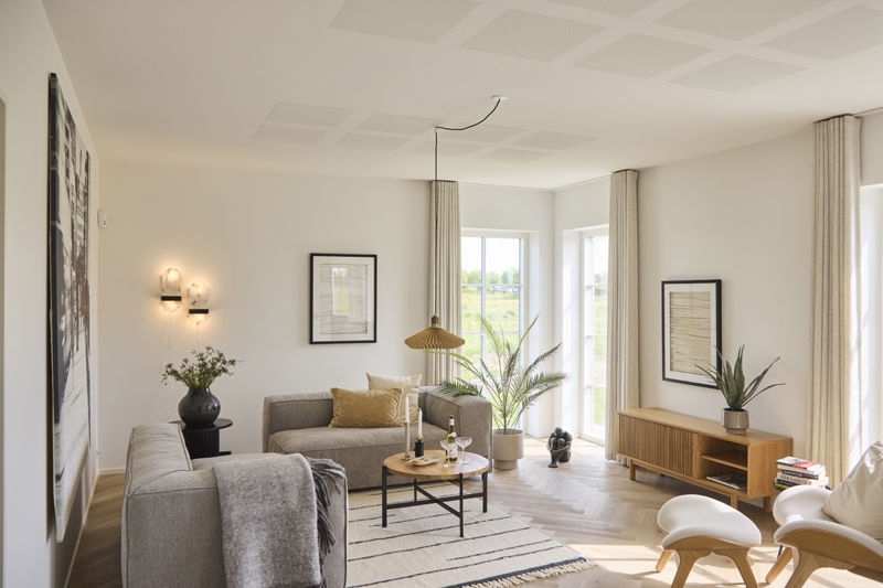 Lys stue i udstillingshus fra eurodan-huse med store vinduespartier, sofaområde, sildebensgulv og moderne indretning, der giver inspiration til nybyggeri, husbyggeri og indretning af et nyt familiehus.