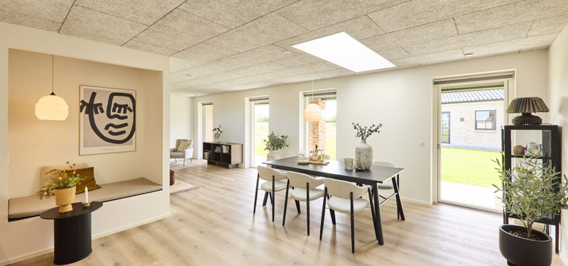 Køkken-alrum i nybygget udstillingshus fra eurodan-huse med ovenlys, langbord, indbygget hyggekrog, store vinduer og lys indretning som inspiration til moderne husbyggeri og husdrømme