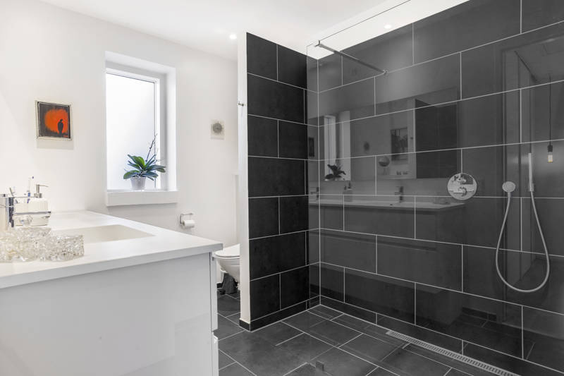 Brusekabine med sorte fliser