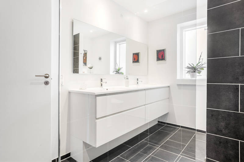 Hvidt moderne badeværelse med grå fliser