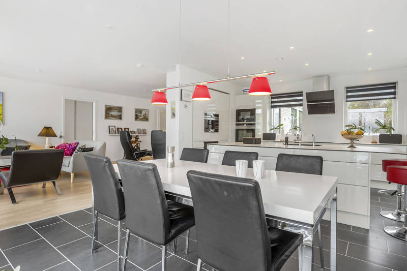 Køkkenalrum med overskiftende gulv og mange stole