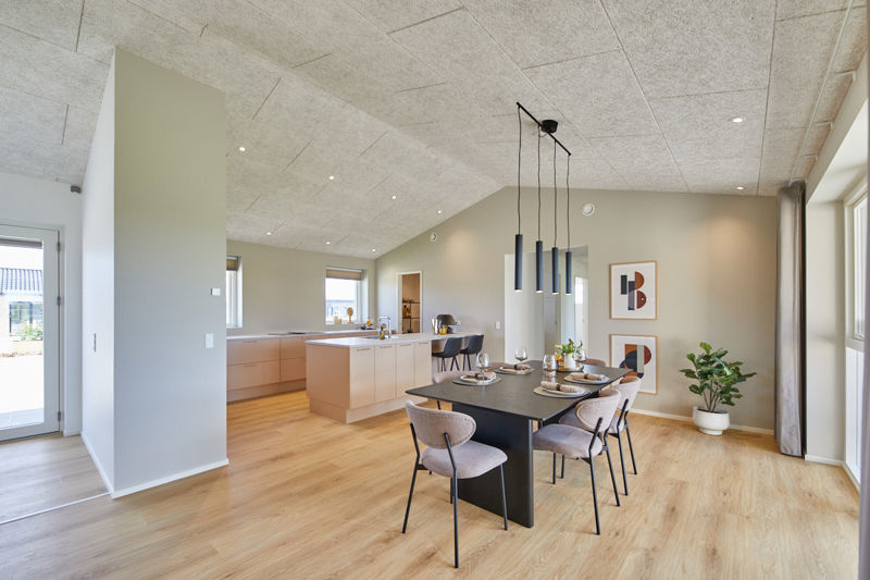 Køkken-alrum i nybygget udstillingshus fra eurodan-huse med sort spisebord, pendellamper, lys køkkenø, akustikloft og store glaspartier som inspiration til moderne husbyggeri og husdrømme