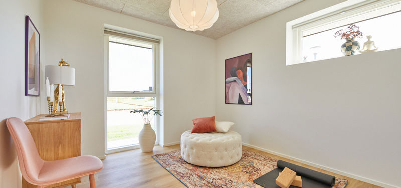 Fleksibelt værelse i nybygget udstillingshus fra eurodan-huse med yogamåtte, loungemøbel, akustikloft og store vinduer som inspiration til personlige husdrømme og moderne husbyggeri