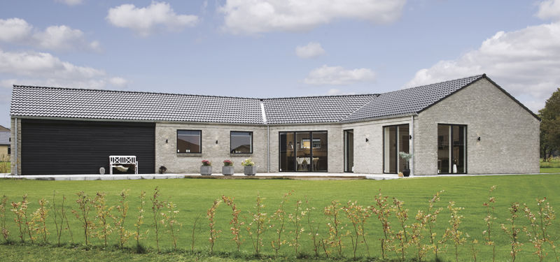 Moderne knækhus på 160 m² med lys murstensfacade, mørkt tegltag, integreret garage, store vinduespartier og en rummelig grøn have – inspiration til nybyg og familiens husdrømme.