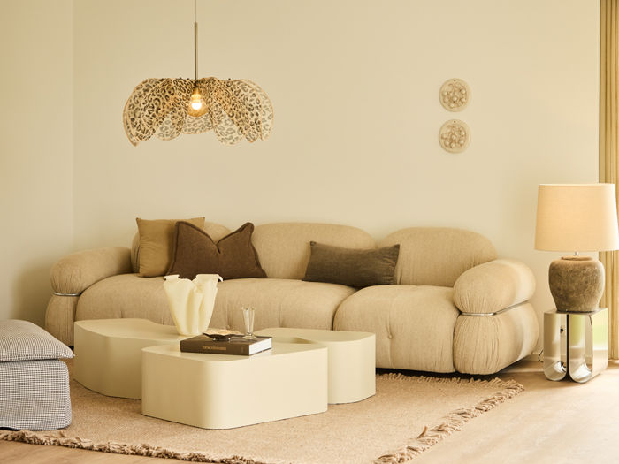 Lys stue fra eurodan-huse med beige modulsofa, firkantet sofabord, stort gulvtæppe, dekorativ pendellampe og gulvlampe ved gardinerne – inspiration til rolig boligindretning, moderne nybyggeri og husdrømme.