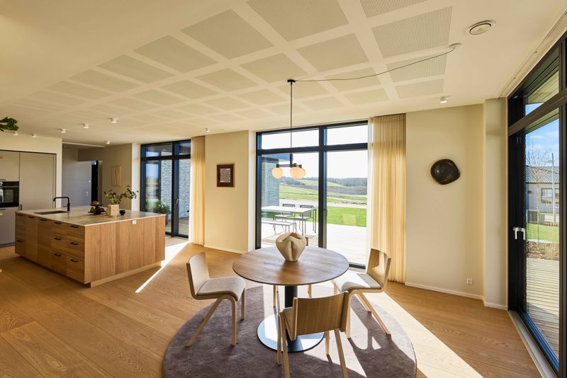 Åbent køkken-alrum med masser af dagslys – hjertet i et moderne husbyggeri i en familievilla