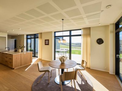 Åbent køkken-alrum med masser af dagslys – hjertet i et moderne husbyggeri i en familievilla