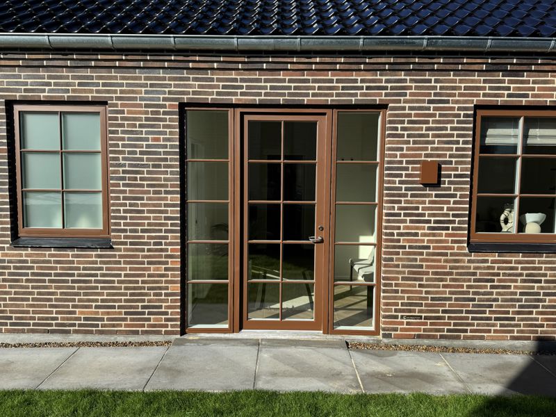 Muret facade med sprossede terrassedøre og klassiske detaljer på et nyt hus fra eurodan-huse