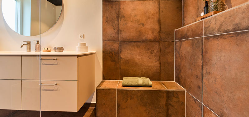 Badeværelse i nybygget udstillingshus fra eurodan-huse med brusebænk, indbygget shampoohylde og elegant løsning til husdrømme