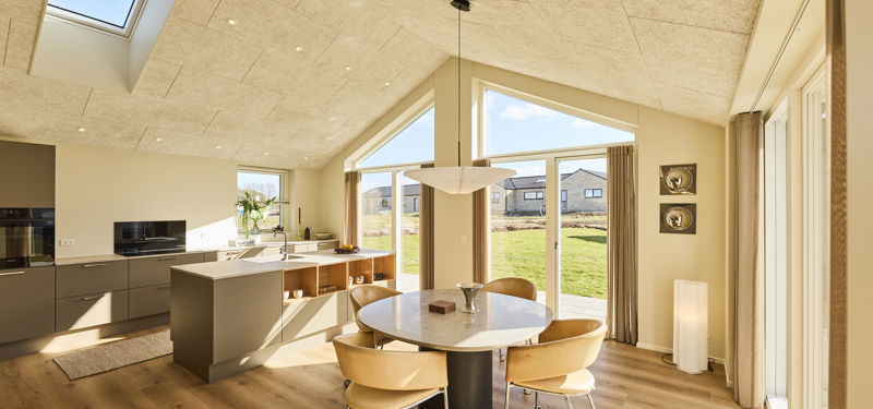 Moderne køkken-alrum i nybyggeri med køkkenø, spiseplads og loft til kip med ovenlys