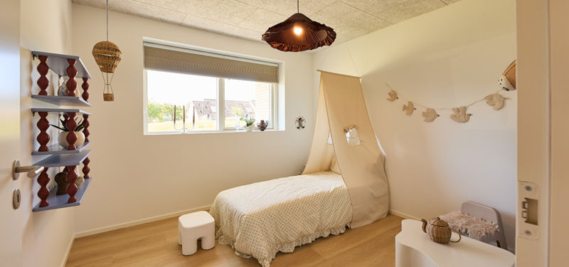 Børneværelse fra eurodan-huse med enkeltseng, sengehimmel, lavt vindue, vægpynt, små hylder og varme pendellamper – inspiration til nybyggeri med hyggelige børneværelser og husdrømme.
