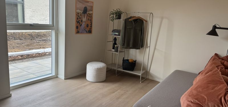 Værelse i nybyggeri med stort vindue, daybed og fleksibel indretning